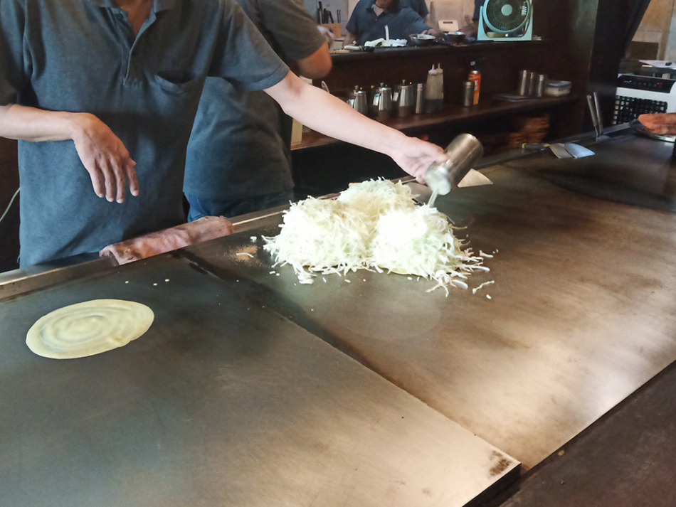スタッフがお好み焼きを作っています